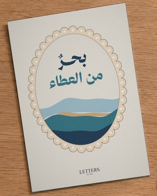 بطاقة إهداء بمقاس A5 عليها رسمة أمواج بحر فيروزية وعبارة «بحرٌ من العطاء»، على طاولة خشبية