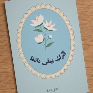 بطاقة إهداء بمقاس A5 عليها رسمة أزهار بيضاء على خلفية زرقاء هادئة وعبارة «أثركِ يبقى دائمًا»، على طاولة خشبية
